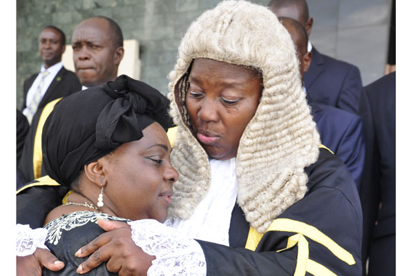 Speaker Rebecca Kadaga comforts Gender minister Mary Karooro Okurut at Parliament yesterday. This was during a special session to honour the minister’s late husband Stanislaus Okurut.  PHOTO BY GEOFFREY SSERUYANGE